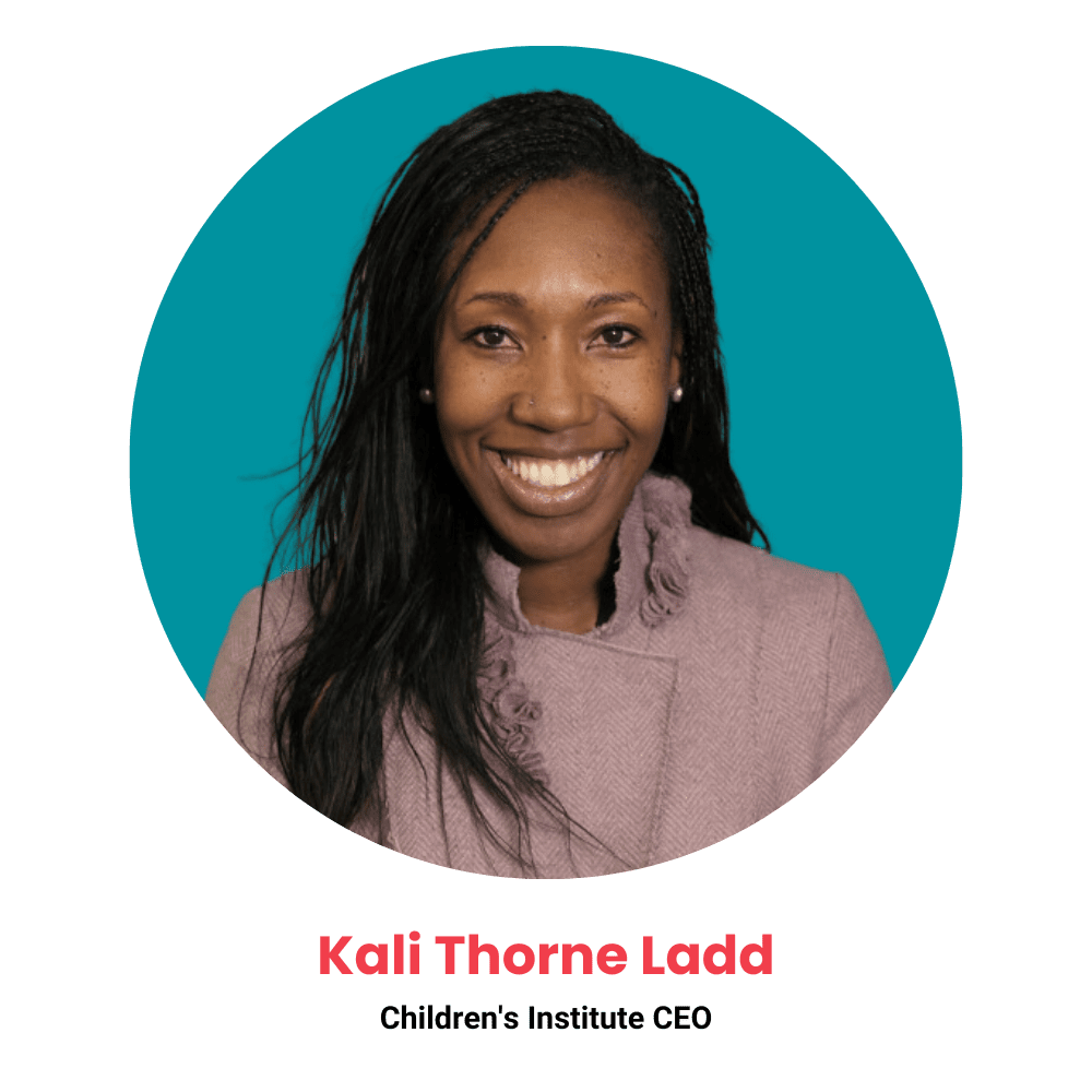 This is a photo of Kali Thorne Ladd, CEO of the Children's Institute. She has brown skin, long dark hair and a cheerful smile. She is wearing a mauve blouse and standing in front of a teal background.