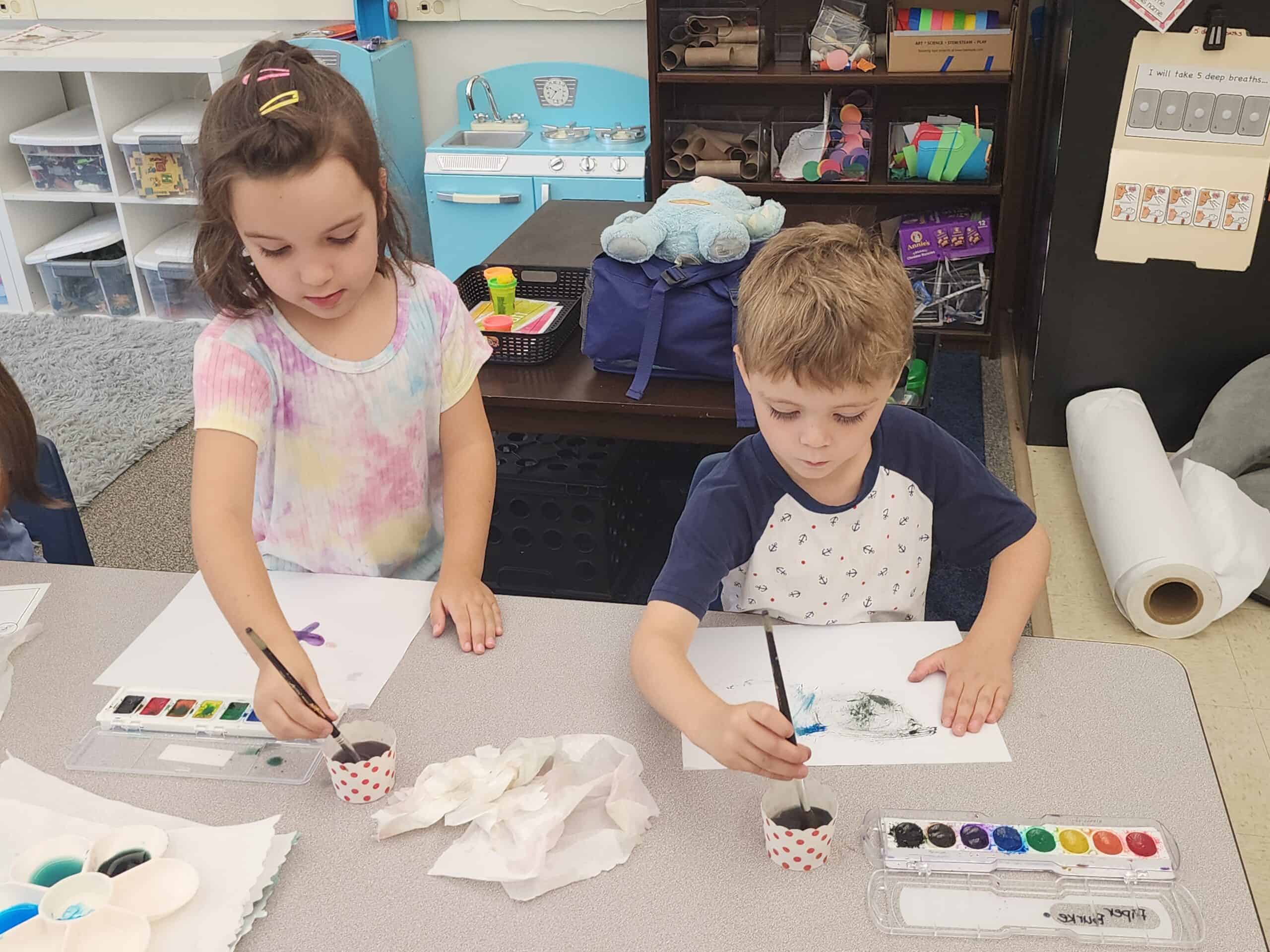 Two students painting at Kinder Camp.