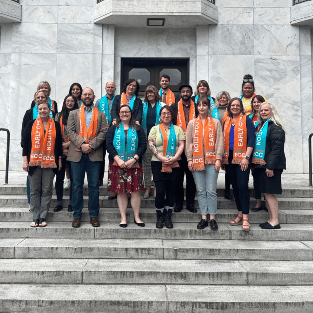 This is an image of early childhood advocates wearing matching scarves and getting ready to for lobby sessions at the Capitol.
