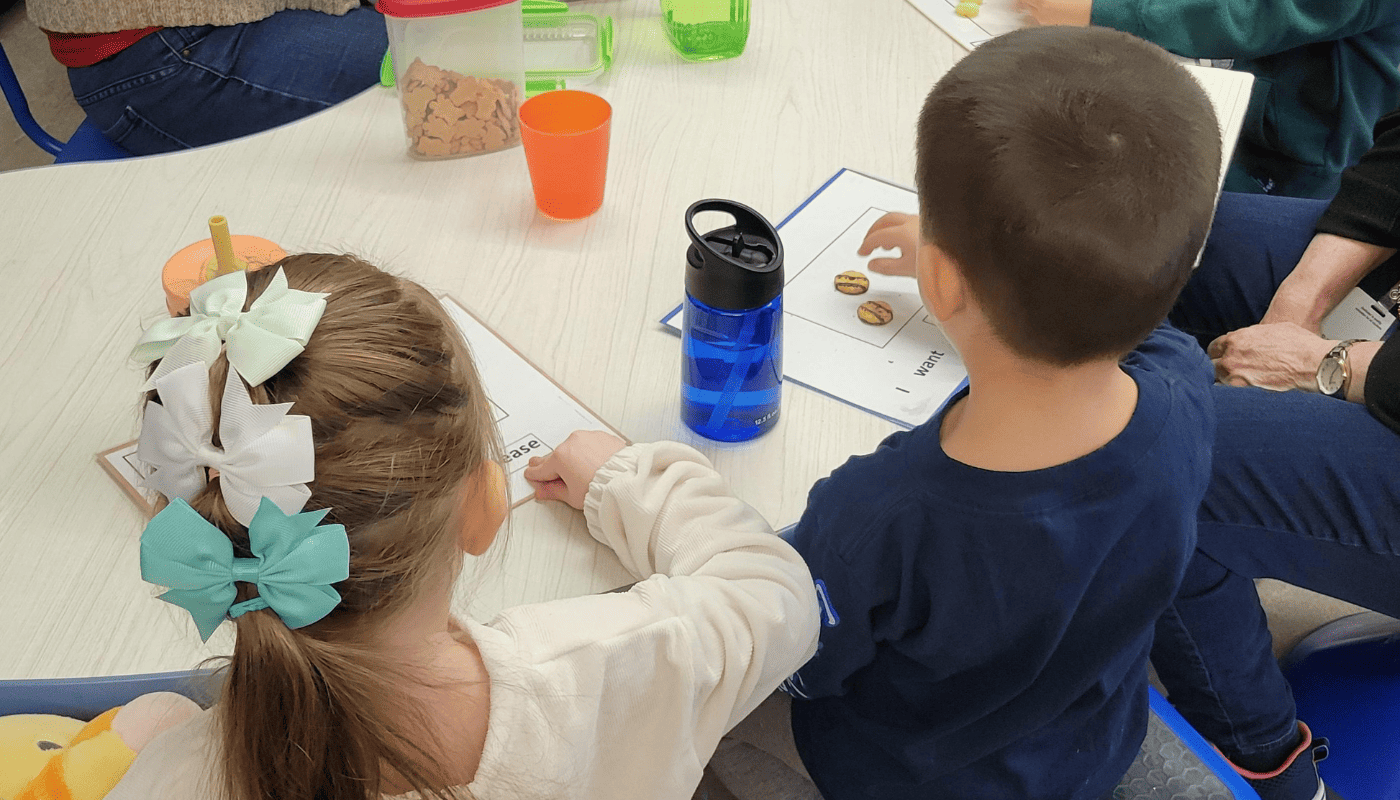 this image features a young boy and a young girl student sitting at a table for snack time in an inclusive classroom at NWRESD.