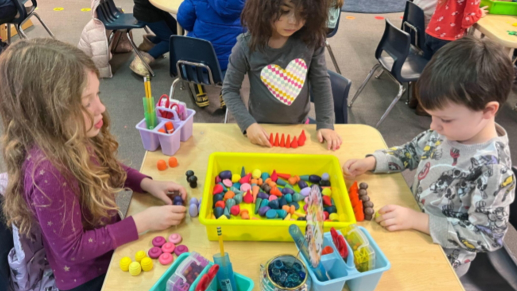 Kids doing activities around a classroom table